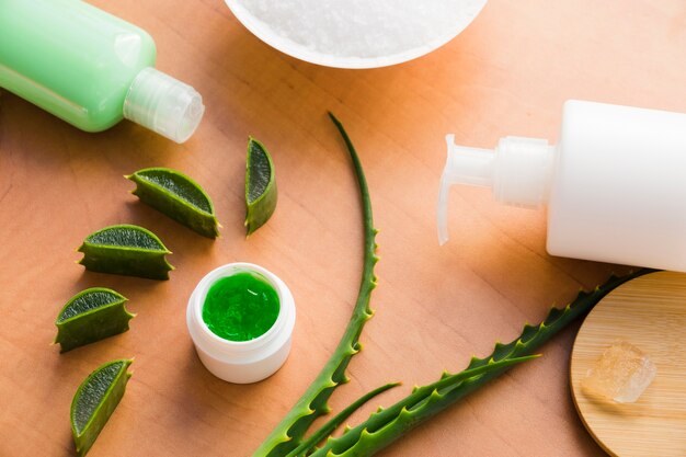 Hojas de aloe vera con un tarro de crema de belleza