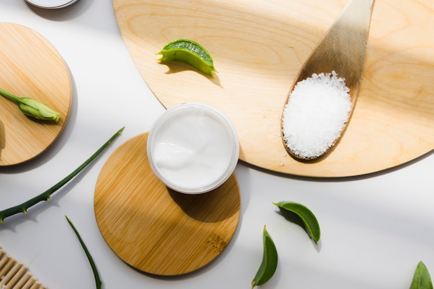 Hojas de aloe vera con un tarro de crema de belleza