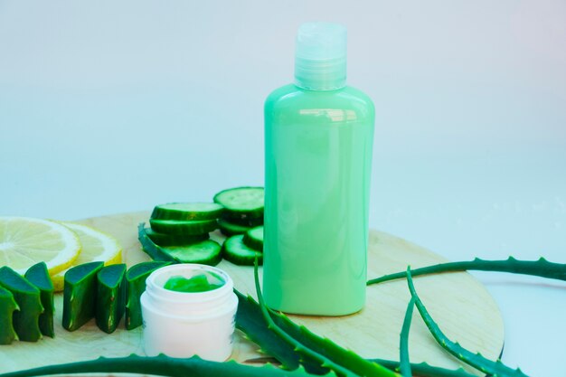 Hojas de aloe vera con un tarro de crema de belleza