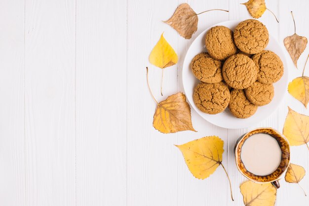 Hojas alrededor de galletas y bebidas