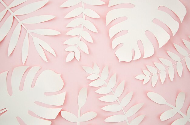 Hojas artificiales estilo de corte de papel con fondo rosa