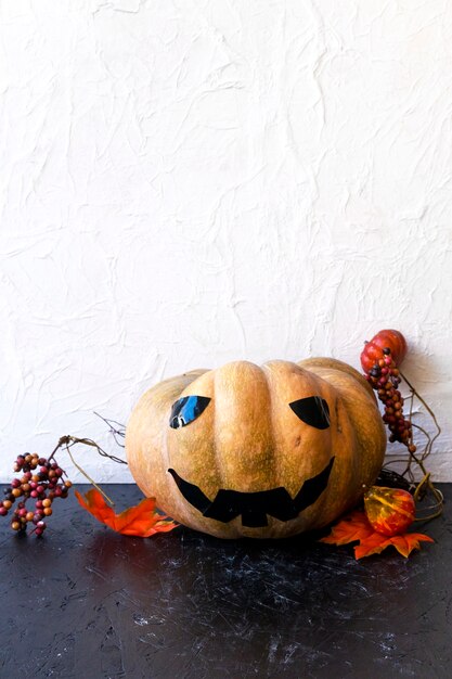 Hojas y bayas cerca de Jack-o-lantern