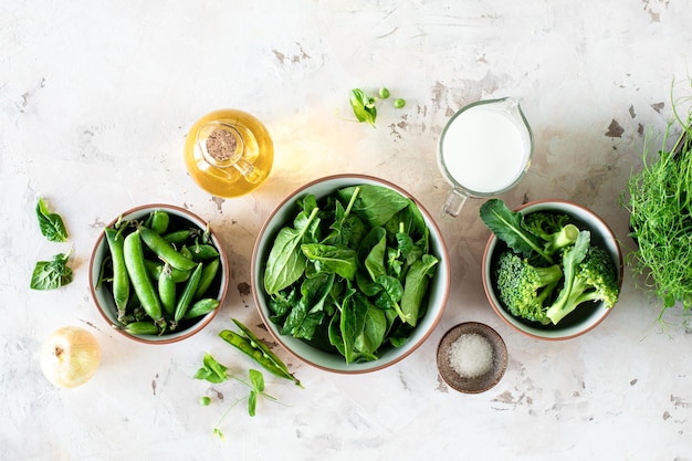 Foto gratuita las hojas de espinaca fresca, los guisantes verdes y el brócoli en un cuenco, vista de arriba