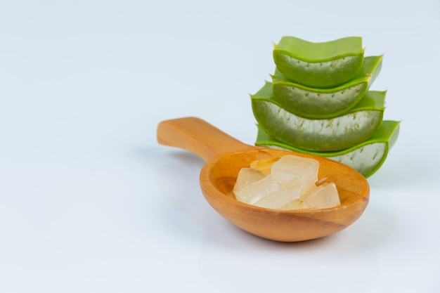 Foto gratuita hojas frescas de aloe vera con rodajas y gel en una cuchara de madera. el aloe vera es un uso natural de hierbas para la belleza.