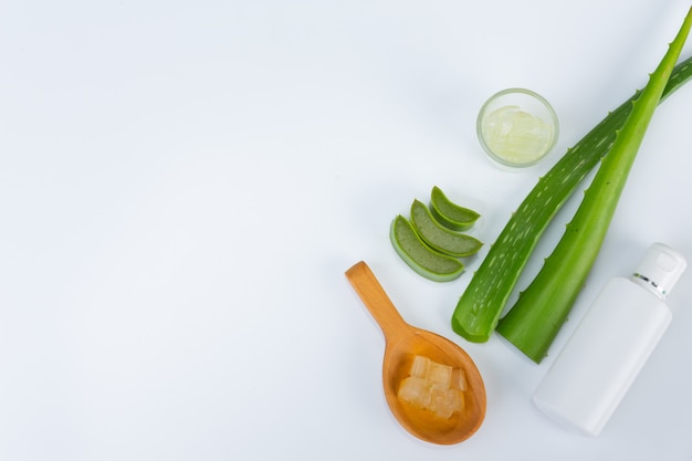 Hojas frescas de aloe vera con rodajas y gel en una cuchara de madera. El aloe vera es un uso natural de hierbas para la belleza.