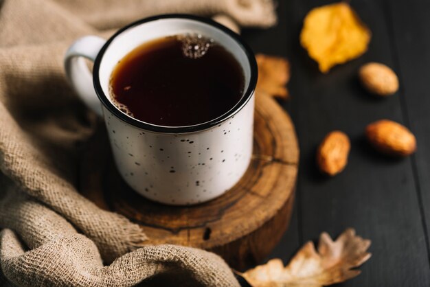 Hojas y granos cerca del té y la tela