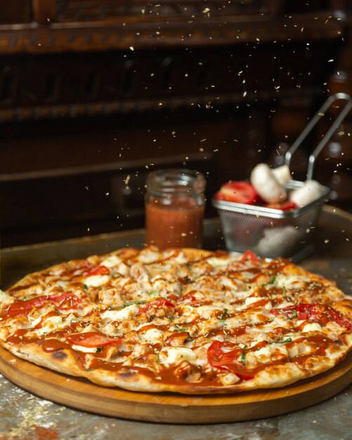 Las hojas de menta secas se rocían sobre la pizza de pollo.