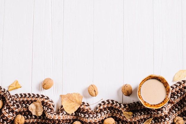 Foto gratuita hojas y nueces cerca de bebida y bufanda