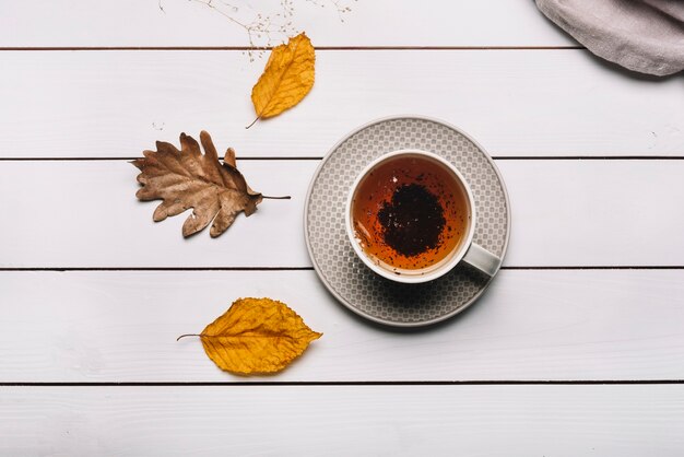 Las hojas de otoño cerca del té