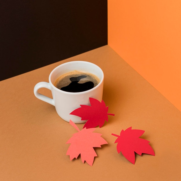 Foto gratuita hojas de otoño de papel junto a la taza de café