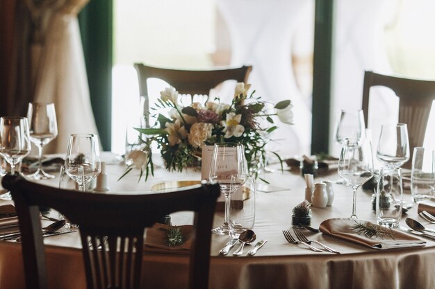 Hojas de pino y bouquet en la elegante mesa decorada