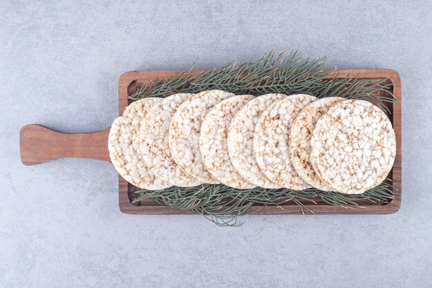 Hojas de pino que adornan una bandeja de galletas en la mesa de mármol.