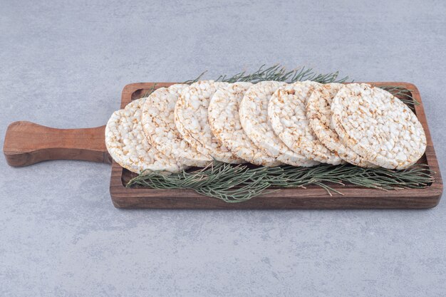 Hojas de pino que adornan una bandeja de galletas en la mesa de mármol.