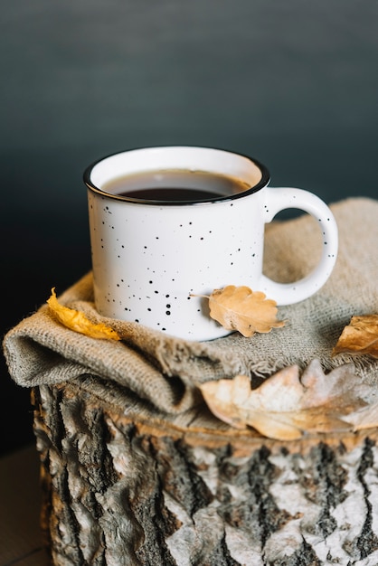 Foto gratuita hojas y taza en tela y tocón