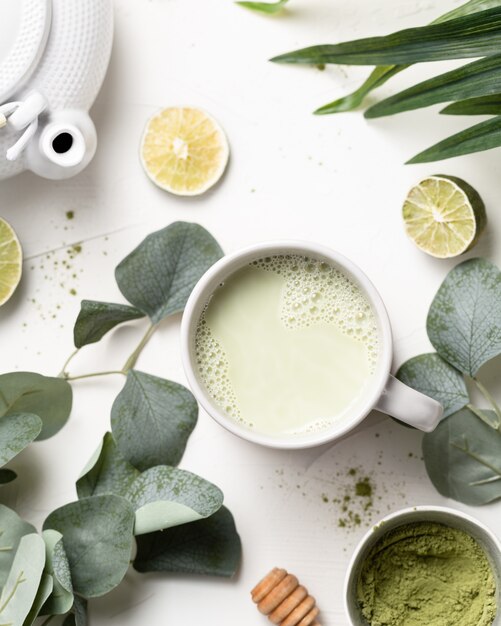 Hojas de té verde matcha y limas en una mesa