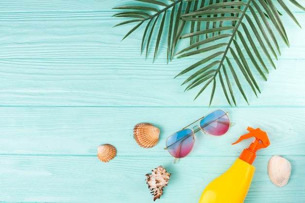 Hojas tropicales con accesorios de playa en composición.