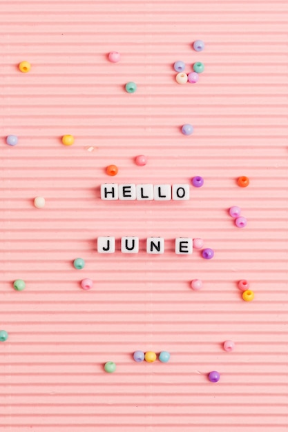Foto gratuita hola junio perlas palabra tipografía en rosa