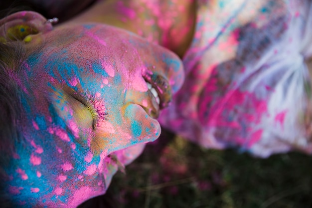 Holi de color sobre el rostro de la mujer.