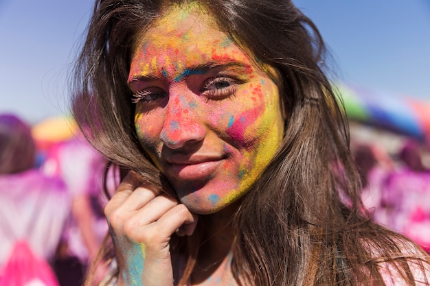 Holi colorido en la cara de la mujer.