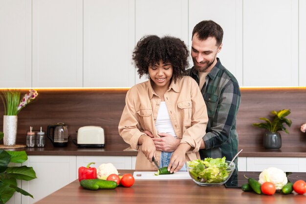 Hombre abrazando a hermosa mujer cocinando