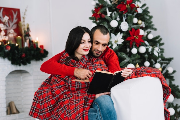 Hombre abrazando a mujer con libro