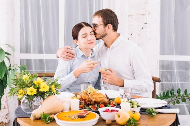 Foto gratuita hombre abrazando a la mujer en la mesa festiva