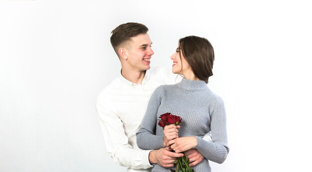 Hombre abrazando a mujer con rosas rojas
