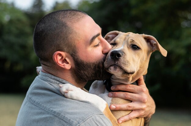 Hombre abrazando a su amigable pitbull