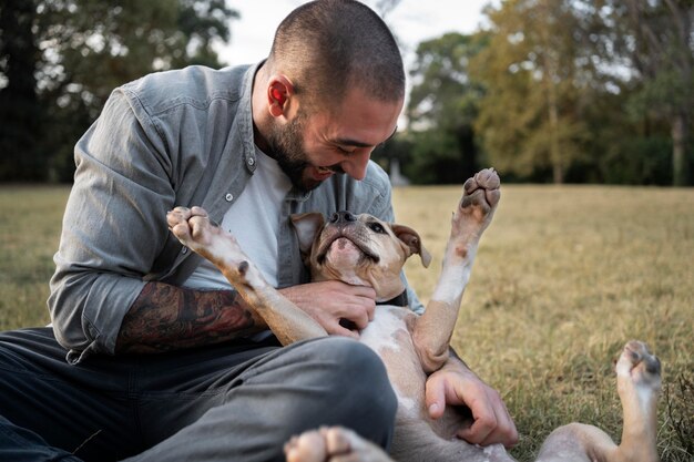 Hombre abrazando a su amigable pitbull