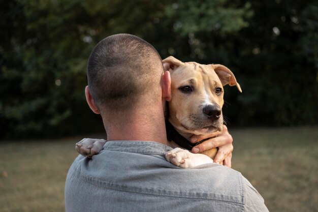 Hombre abrazando a su amigable pitbull