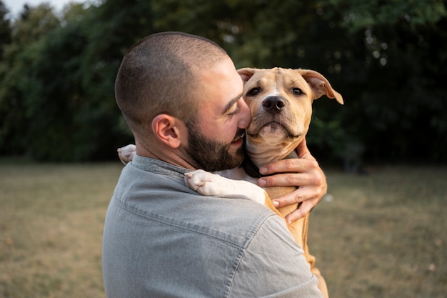 Hombre abrazando a su amigable pitbull