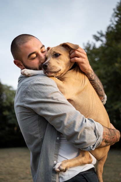 Hombre abrazando a su amigable pitbull