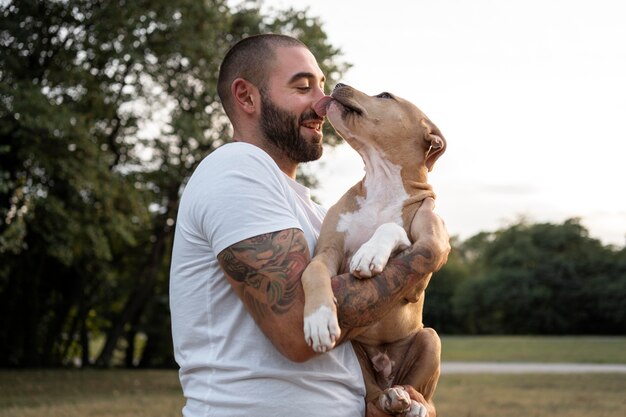 Hombre abrazando a su amigable pitbull