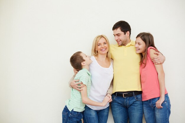 Hombre abrazando a su familia idílica