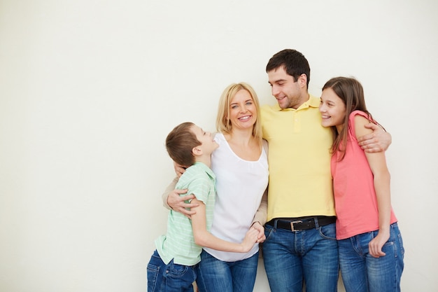 Hombre abrazando a su familia idílica