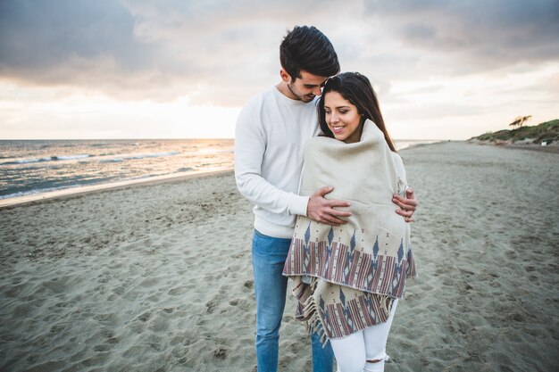 Hombre abrazando a su novia en la playa
