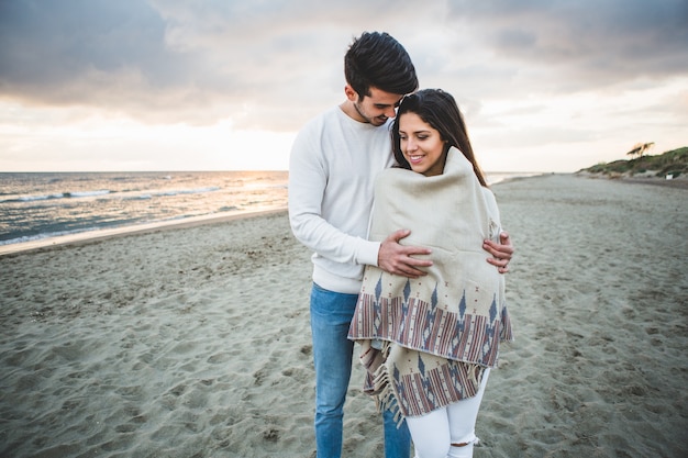 Hombre abrazando a su novia en la playa