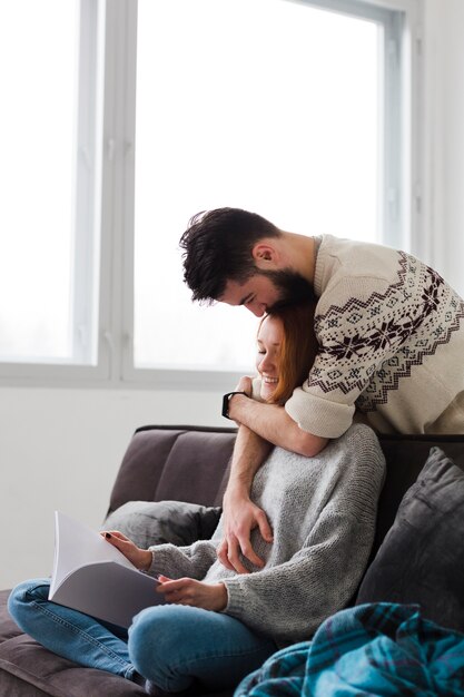 Hombre abrazando a su novia en la sala de estar