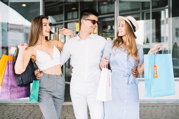 Hombre abrazando a sus amigas