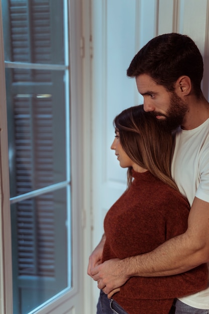 Foto gratuita hombre, abrazar, mujer, cerca de ventana