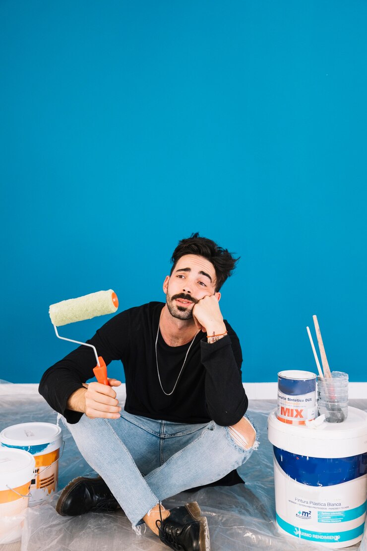 Foto gratuito hombre aburrido con materiales de pintura