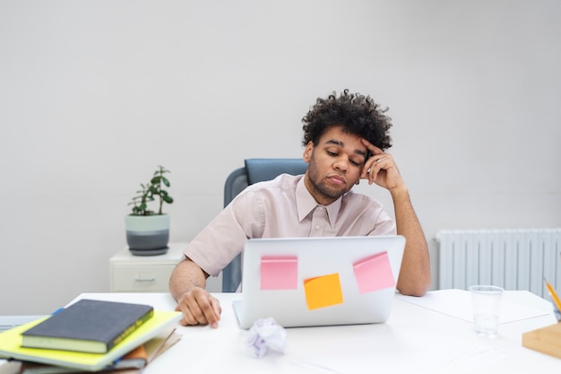 Foto gratuita hombre aburrido de plano medio en el trabajo