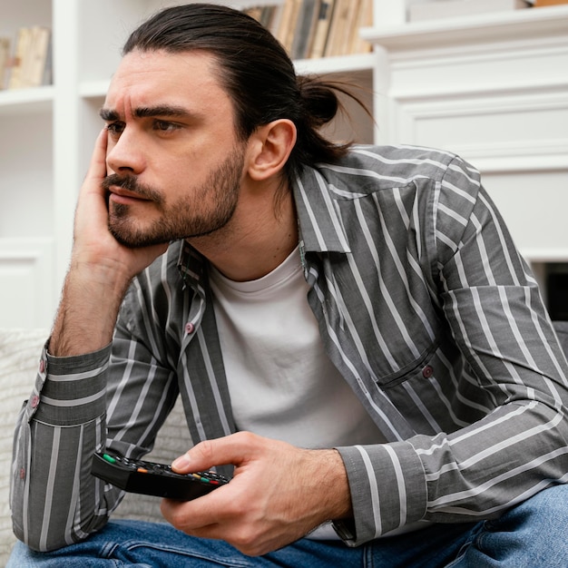 Foto gratuita hombre aburrido tratando de encontrar algo para ver en la televisión