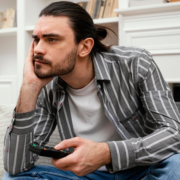 Hombre aburrido tratando de encontrar algo para ver en la televisión