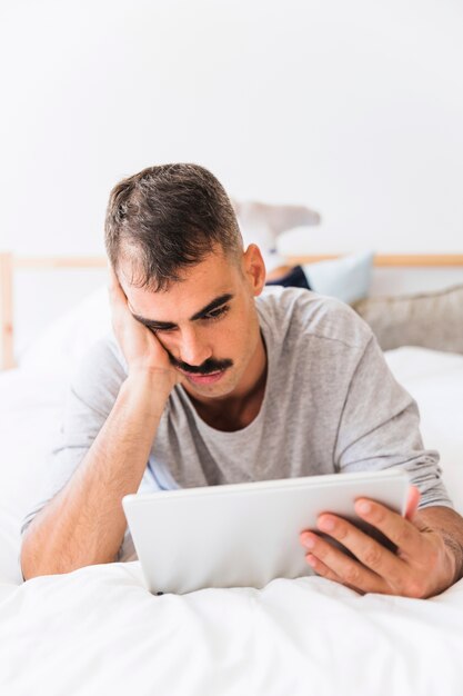 Hombre aburrido viendo la película en tableta