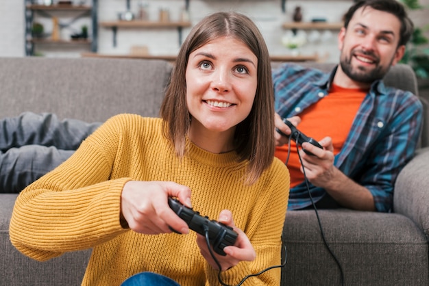 Foto gratuita hombre acostado en el sofá jugando videojuegos con su esposa