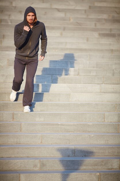 Hombre activo corriendo por las escaleras de la ciudad