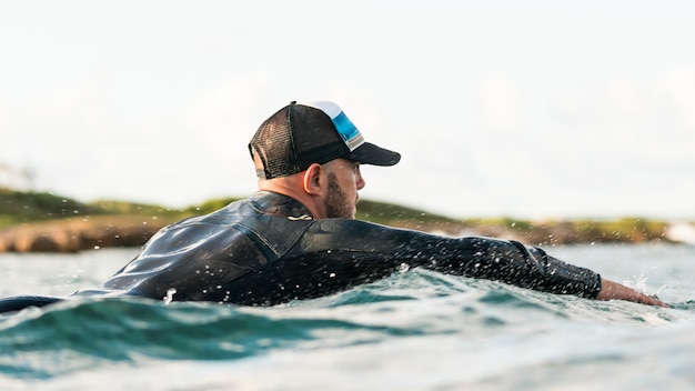 Hombre activo en equipo especial alojado en una tabla de surf