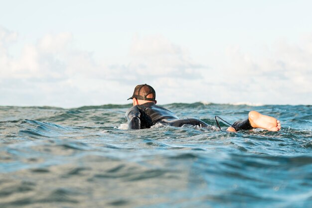 Hombre activo en equipo especial alojado en una tabla de surf