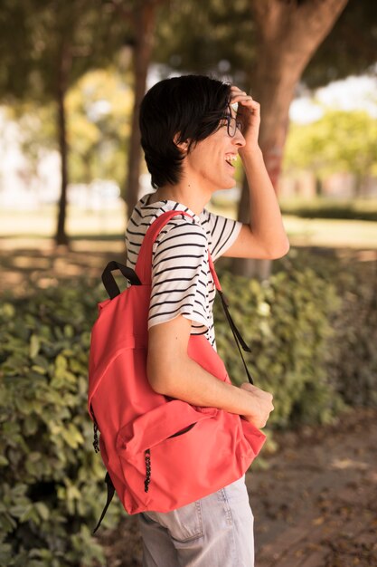 Hombre adolescente asiático con mochila riendo